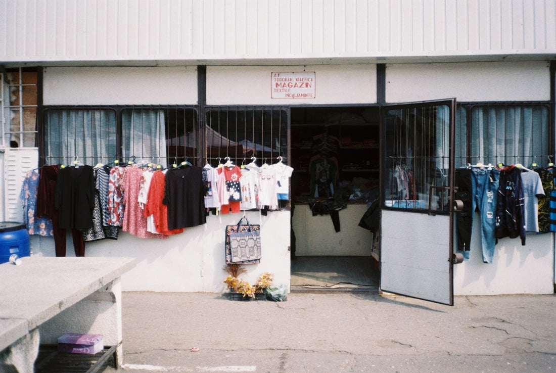 a clothing store with clothes hanging outside of it