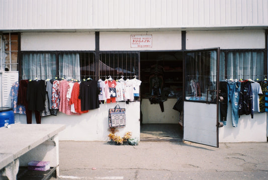 a clothing store with clothes hanging outside of it