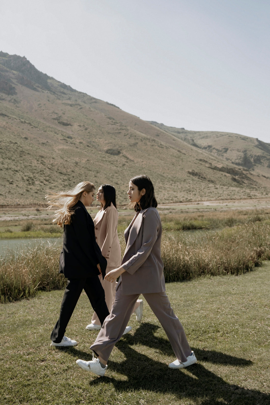 a group of women walking across a lush green field