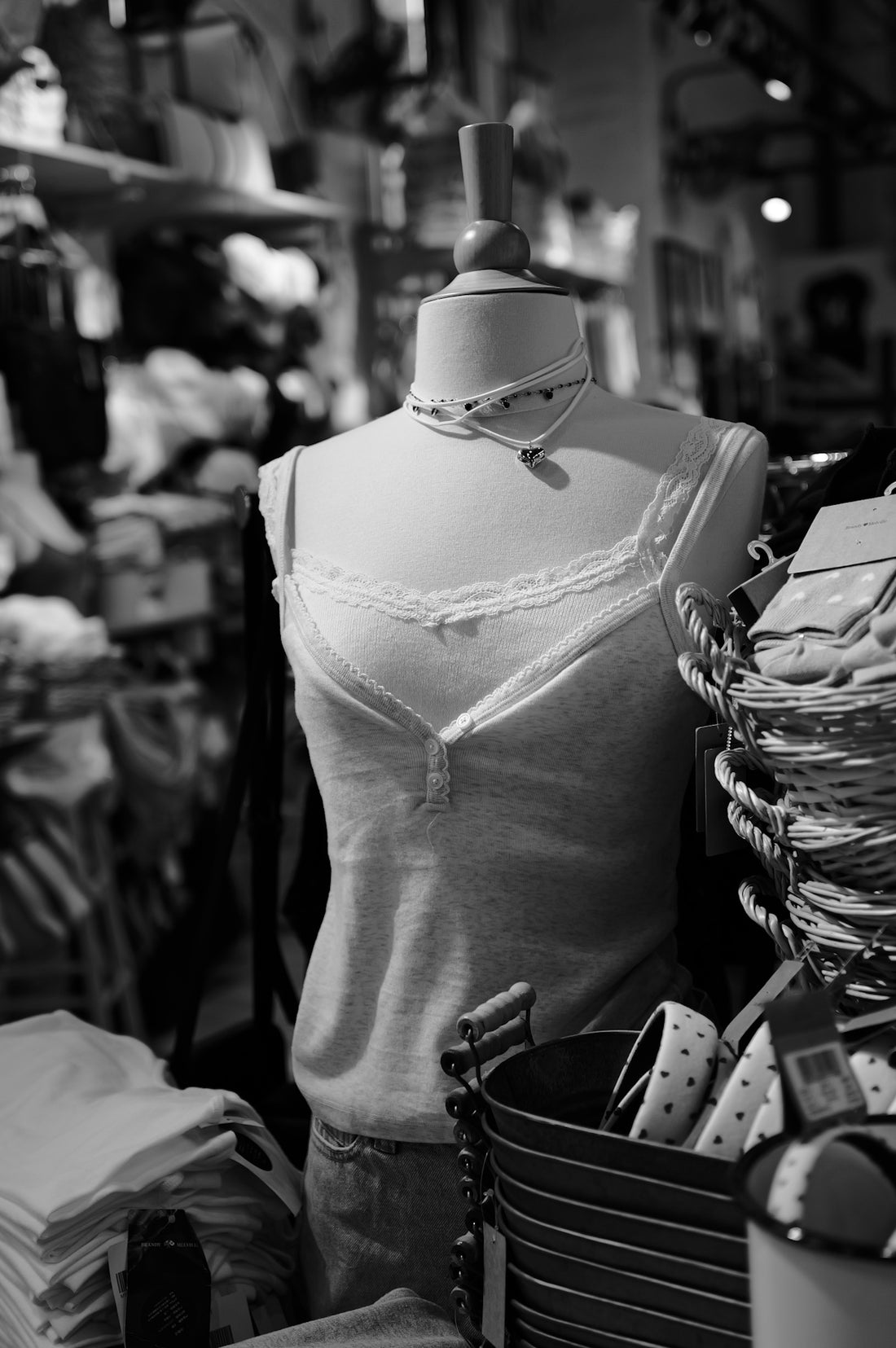 A black and white photo of a mannequin in a clothing store