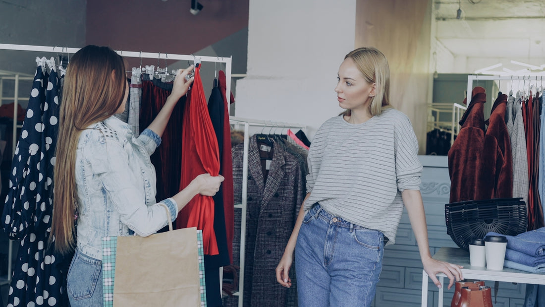 Two women shop for clothes in a boutique.