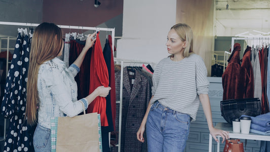 Two women shop for clothes in a boutique.