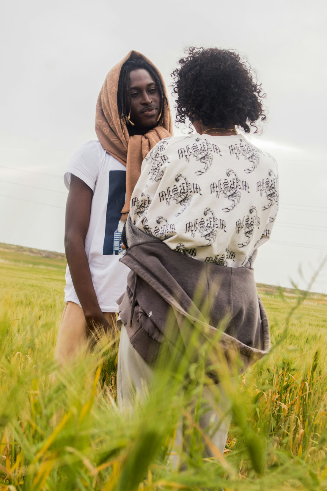 Two people embrace in a field of tall grass