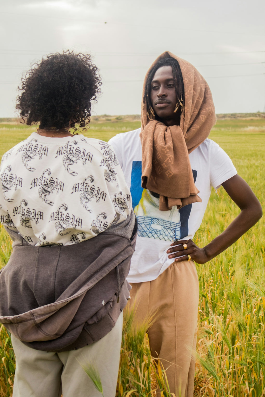 Two people are standing in a field of wheat.