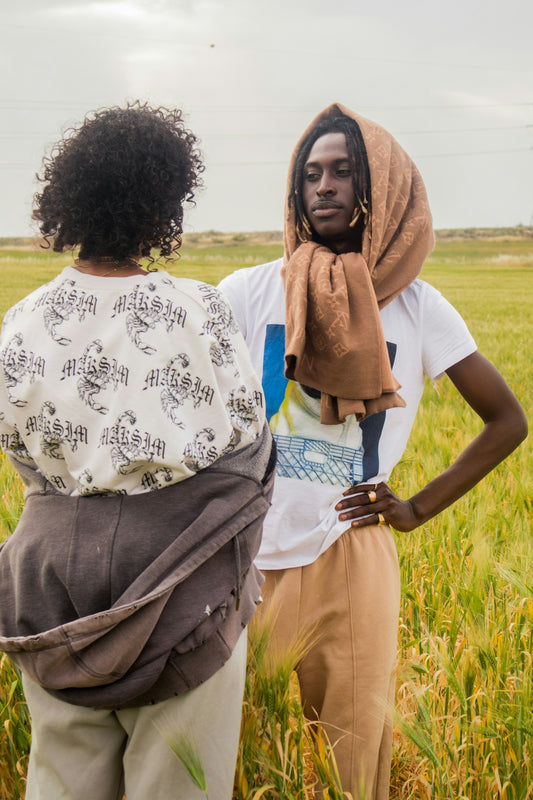 Two people are standing in a field of wheat.