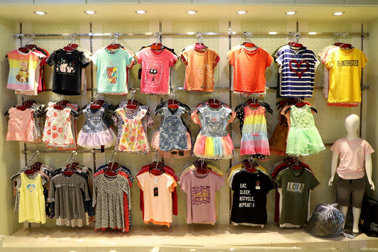Children's clothing displayed on racks in a store.