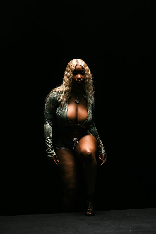 A woman with blonde hair poses in a dark room.