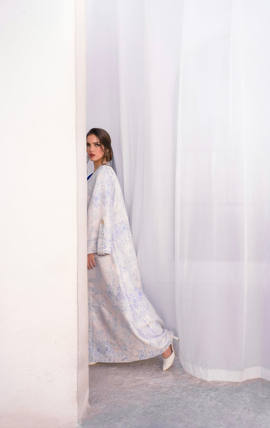 Woman in a patterned dress peeking around a corner