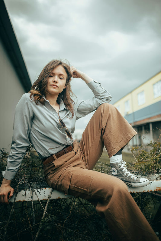 Woman in stylish outfit sitting outdoors