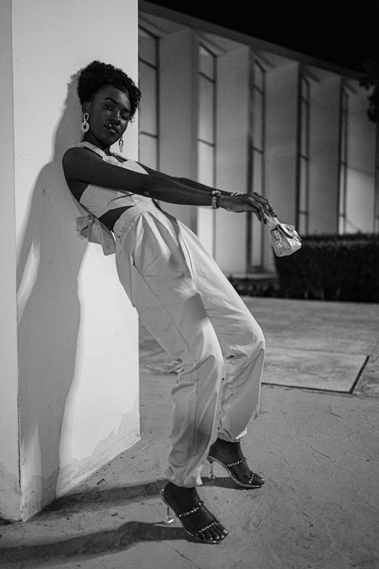 Woman in fashionable outfit posing by a wall