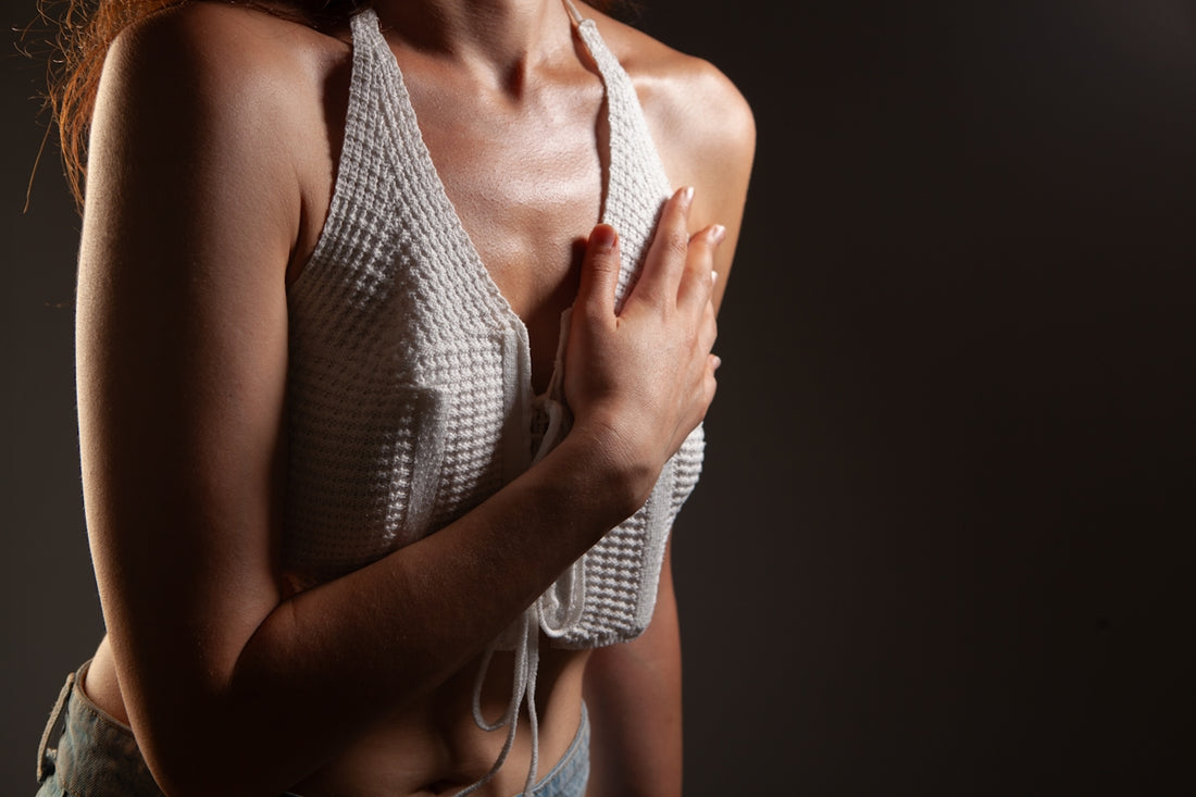 Woman in white halter top holding chest