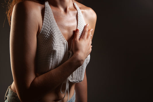 Woman in white halter top holding chest