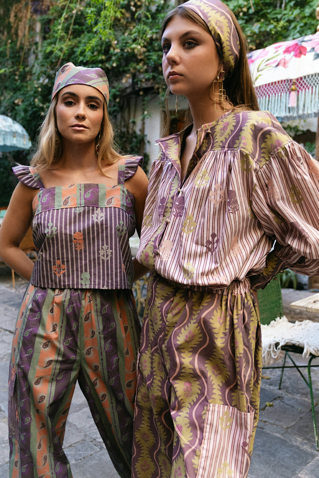 Two women modeling patterned bohemian clothing outdoors.