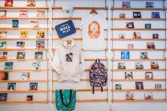 Retail wall display with clothing, a backpack, and small products.