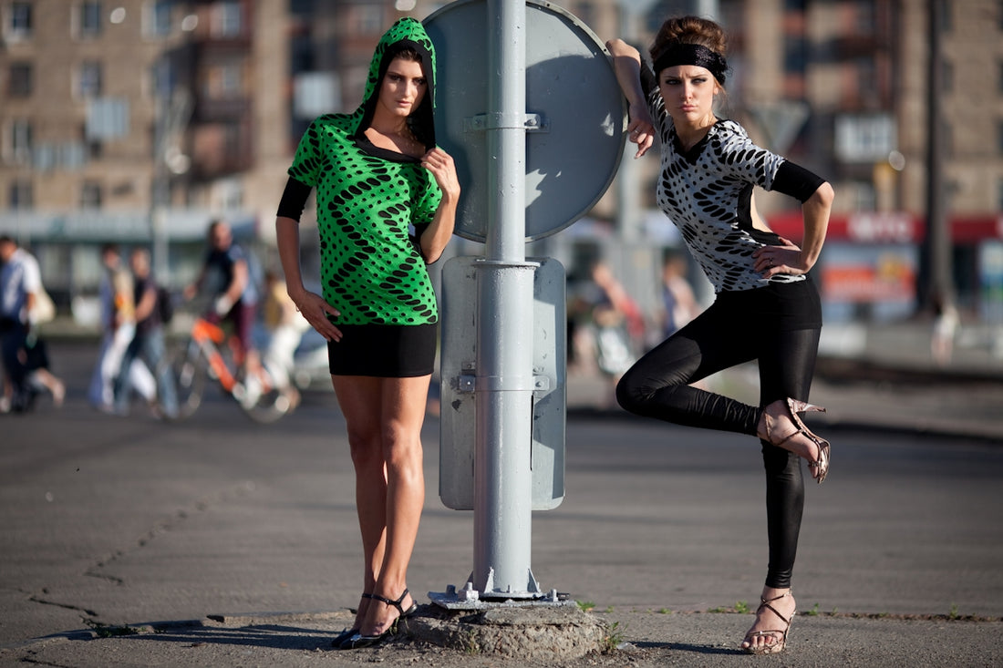 Two fashionable women posing on a city street.