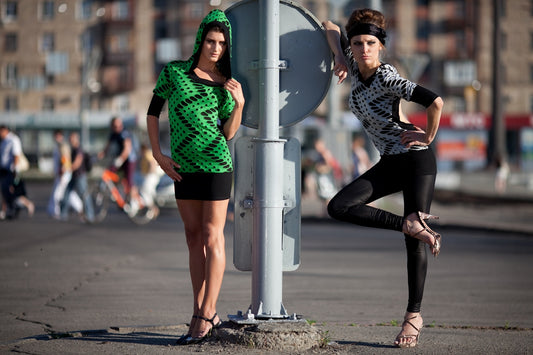 Two fashionable women posing on a city street.